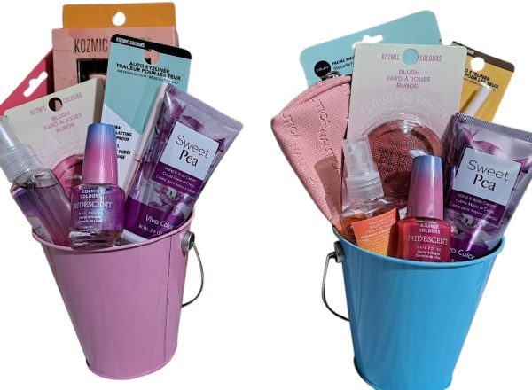 Two Automotive Baskets, one pink and one blue, containing beauty products. Items include Sweet Pea hand sanitizer, iridescent nail polish, blush, a face mask, and a pair of scissors. The baskets are filled to the brim with neatly arranged cosmetics and accessories.