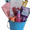 An Automotive Basket filled with various cosmetic items including a pink blush, a tube of purple nail polish, a facial mask, and hand cream labeled "Sweet Pea," a spray bottle, and a beige-colored item. Some items are labeled "KOZMIC COLOURS" and "GLOBAL BEAUTY CARE.