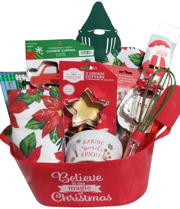 A red Automotive Basket with "Believe in the magic of Christmas" text contains festive kitchen items including cookie cutters, a festive towel, a whisk, straws, a tree-shaped spatula, a mixing bowl, and other baking accessories adorned with Christmas decorations.