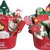 Two Automotive Baskets, resembling festive containers, are filled with assorted Christmas-themed kitchen items like cookie cutters, spatulas, whisks, pot holders, and napkins. One basket has "Believe in the magic of Christmas" text and the other says "Merry Christmas." Festive packaging and decorations are visible.