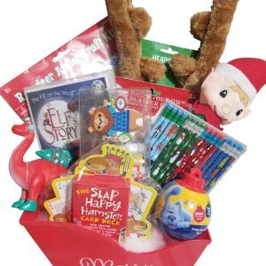 The Automotive Basket is a festive red box with the words "Merry Christmas" and is filled with various holiday-themed items. Contents include an elf doll, reindeer antlers, a dinosaur figurine, colored pencils, a card deck, books, and other small toys—all neatly arranged like a holiday basket.