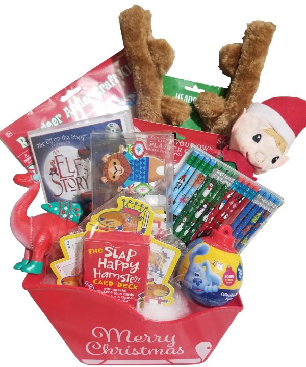 The Automotive Basket is a festive red box with the words "Merry Christmas" and is filled with various holiday-themed items. Contents include an elf doll, reindeer antlers, a dinosaur figurine, colored pencils, a card deck, books, and other small toys—all neatly arranged like a holiday basket.