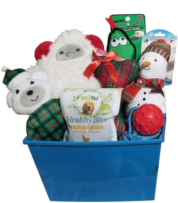 A blue Automotive Basket filled with various dog toys and treats, including plush holiday-themed items such as a snowman, a bear, and a sheep, plus a bag of OluPet Healthy Bites chicken-flavored dog treats. The toys are adorned with festive colors and patterns.