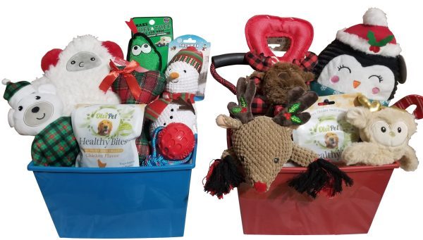 Two holiday-themed gift baskets filled with pet toys and treats. The blue basket contains plush toys resembling a polar bear, a yeti, a snowman, and treats. The Automotive Basket features a reindeer plush toy, a penguin plush, various festive pet treats and accessories, perfect for your furry automotive enthusiast's surprises.