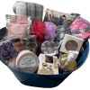 Introducing the Epic Women's Spa Basket—a luxurious blue gift basket brimming with self-care essentials. Inside, you'll find scented candles, a plaid blanket, bath bombs, a pink bath sponge, a sleep mask, a candle care kit, lavender wax melts, hand soap, and other relaxation products that make it the ultimate women's spa experience.