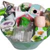 An automotive-themed basket brimming with gardening supplies, including seed packets, small pots—with one pot featuring the message "Give yourself time to grow"—a lavender grow kit, plant markers, a glass bottle, and garden gloves. The items are attractively arranged.