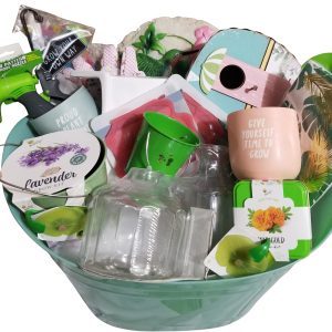 An automotive-themed basket brimming with gardening supplies, including seed packets, small pots—with one pot featuring the message "Give yourself time to grow"—a lavender grow kit, plant markers, a glass bottle, and garden gloves. The items are attractively arranged.