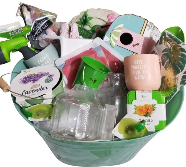 An automotive-themed basket brimming with gardening supplies, including seed packets, small pots—with one pot featuring the message "Give yourself time to grow"—a lavender grow kit, plant markers, a glass bottle, and garden gloves. The items are attractively arranged.