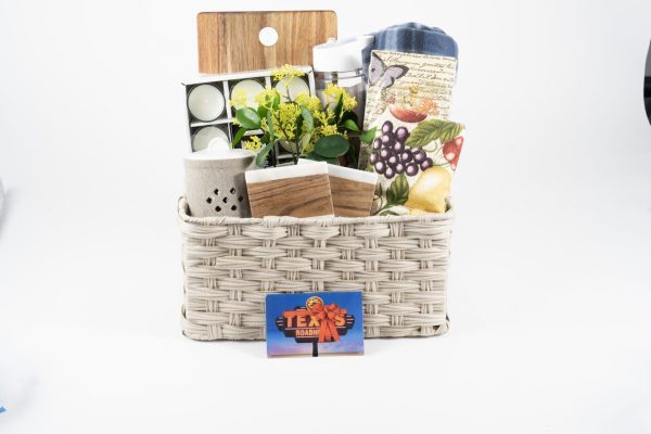 The "Kitchen & Home Large with $50 in Texas Roadhouse Certificates" features a woven basket containing a small plant, a set of tea lights, a kitchen cutting board, a fruit-print towel, a ceramic container, a wooden box, and a stainless steel tumbler. In front of the basket is also included a gift card for Texas Roadhouse worth $50.