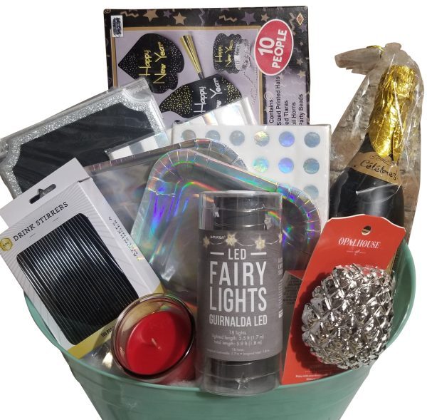 An Automotive Basket, filled with New Year's Eve celebration items, including LED fairy lights, black drink stirrers, a candle, shiny party hats, a pack of napkins, a notebook with a holographic cover, a bottle of sparkling wine, and a glittery silver ornament—the perfect way to rev up your festivities.