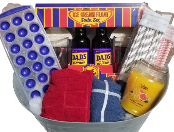 An Automotive Basket contains an ice cream float soda set with Dad's Root Beer bottles, a blue ice cube tray, red and blue dish towels, a yellow citrus-scented candle, and paper straws with red and gray patterns. Perfect for any occasion, this basket adds a touch of charm to your gathering.