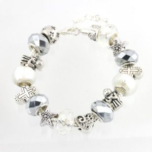 The Salt and Light Bracelet is a silver charm bracelet adorned with an array of elegant beads and charms. The beads feature shiny silver, textured and patterned silver, as well as pearly white designs. The charms include petite stars, hearts, angels, and intricate patterns, all linked together by a delicate silver chain with a secure clasp.