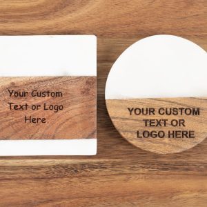 Two coasters rest on a wooden surface. The left coaster is square, featuring a white top half and wood bottom half, with text reading "Your Custom Text or Logo Here." The right coaster is circular with a similar design and text reading "YOUR CUSTOM TEXT OR LOGO HERE." These are perfect for bulk orders of 50 or more under the product name Coasters - Bulk order of 50.