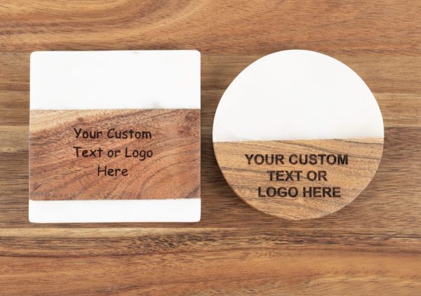 Two coasters rest on a wooden surface. The left coaster is square, featuring a white top half and wood bottom half, with text reading "Your Custom Text or Logo Here." The right coaster is circular with a similar design and text reading "YOUR CUSTOM TEXT OR LOGO HERE." These are perfect for bulk orders of 50 or more under the product name Coasters - Bulk order of 50.