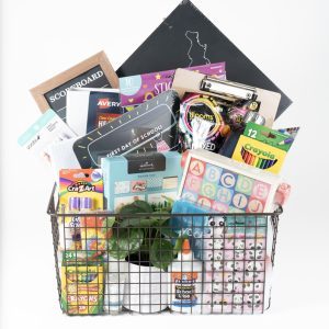 The Adult Gambling Night Basket is filled with a wire basket containing various items for organizing your event, including crayons, notebooks, stickers, glue, pencils, a ruler, ABC flashcards, a plant, and decorative items. Perfect for adults planning an educational fun night in. The assortment also features a scoreboard and a state-shaped chalkboard.