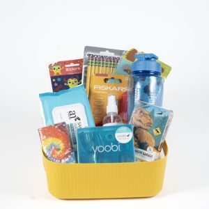 A yellow rectangular basket filled with assorted school supplies including a blue water bottle, a pack of Fiskars scissors, a set of colored markers, a packet of baby wipes, a pack of stickers, an adult notepad, hand sanitizer, and a tie-dye notebook has been renamed as the "Adult Gambling Night Basket.