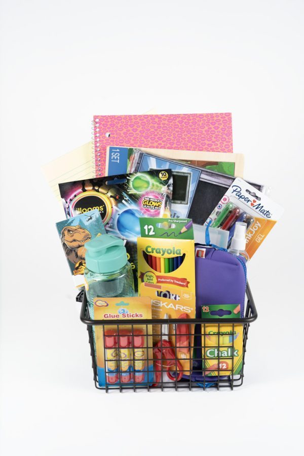 An Adult Gambling Night Basket contains a black wire basket filled with various school supplies, including notebooks, folders, glue sticks, colored pencils, scissors, a water bottle, chalk, markers, and pens. The assorted items are neatly arranged and ready for use by adults burning the midnight oil.