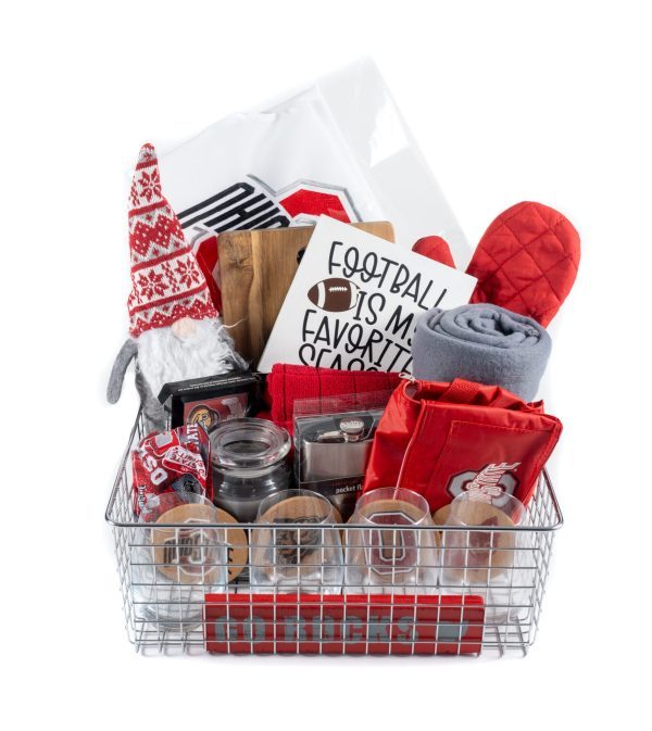 A Personalized Buckeye Basket, complete with 4 custom glasses, a cutting board, and various football-themed items such as a decorative sign reading "Football is my favorite season," a gnome plush, a gray blanket, a red oven mitt, mason jars, and other themed kitchen and home accessories.