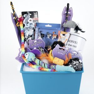 Introducing the Adult Gambling Night Basket: a blue gift basket filled with assorted cat toys and themed items. It includes a multicolored ribbon toy, plush mice, feather toys, a small sword toy, a mug adorned with a cat image, and purple tags reading "cat toy." It's the perfect treat for an adult who loves to pamper their feline friend after an exciting evening out.