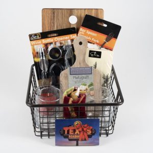 The Celebration Basket with Wine Theme AND $50 in Texas Roadhouse Certificates is filled with a variety of items, including a wine bottle opener set, a bar spoon and garnish fork, a small wooden chopping board, a round red plaid item with a bow, Texas Roadhouse Certificates worth $50, and other bar-related accessories. Perfect for any occasion!