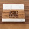 Introducing the "Jesus is my Rock & that's how I Roll - Square" coaster, crafted from a blend of white marble and wood. The wooden section elegantly features the engraving "JESUS IS MY ROCK & THAT'S HOW I ROLL." Resting on a wooden surface, this coaster seamlessly integrates rustic charm with spiritual inspiration.