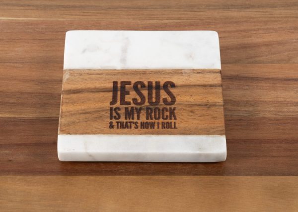 Introducing the "Jesus is my Rock & that's how I Roll - Square" coaster, crafted from a blend of white marble and wood. The wooden section elegantly features the engraving "JESUS IS MY ROCK & THAT'S HOW I ROLL." Resting on a wooden surface, this coaster seamlessly integrates rustic charm with spiritual inspiration.