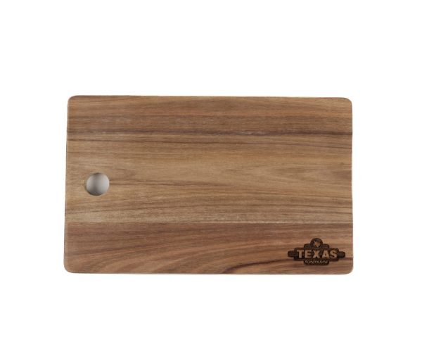 A Custom Cutting Board with a smooth finish and a rounded rectangular shape features a small hole in the upper left corner for hanging. An etched custom logo in the bottom right corner reads "TEXAS Cooking.