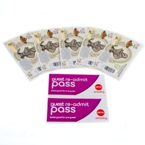 The image depicts seven animal-themed tickets arranged in a fanned-out pattern, showcasing cartoon rhinoceros artwork. Below these tickets are two AMC guest re-admit passes, ideal for inclusion in the Date Night Basket - Texas Road House Dinner & 2 Movie Passes. These passes feature a purple and white design labeled "ticket good for one guest.