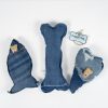 Three denim dog toys are arranged on a white background. The toys, shaped like a fish, bone, and heart, each come with a small treat or chew piece and some distressed denim elements. Perfect for keeping your adult dog's night fun and engaging. There is also a hanging tag labeled "Adult Gambling Night Basket.