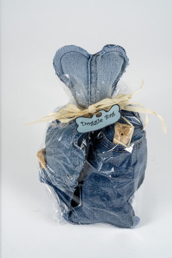 A gift bag wrapped in clear plastic, containing dog treats and two heart-shaped denim fabric decorations, perfect for an adult night of fun. Adorned with a raffia ribbon and labeled "Adult Gambling Night Basket.