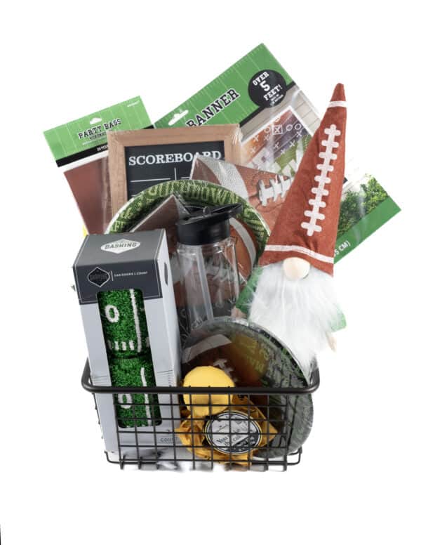 The Football Game Day Gift Basket is a rectangular black wire basket filled with diverse football-themed party items, such as a gnome wearing a football hat, disposable cups, plates, a water bottle, napkins, a short green and white tumbler designed to look like a football field, party bags, and a game day planner.