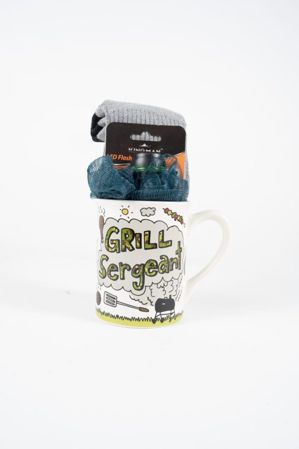 A white ceramic Grill Sergeant Mug Gift Basket with colorful illustrations, filled with gray socks and teal scrubbies, on a white background, includes a complimentary free food certificate.