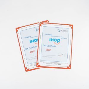 An IHOP $50 Certificate lies against a white background. The certificate is enclosed in a red-bordered holder and prominently displays the IHOP logo in blue. The readable text on the certificate indicates its value and usage terms, providing a $50 dining experience.