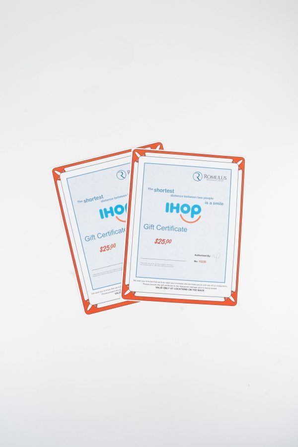 An IHOP $50 Certificate lies against a white background. The certificate is enclosed in a red-bordered holder and prominently displays the IHOP logo in blue. The readable text on the certificate indicates its value and usage terms, providing a $50 dining experience.