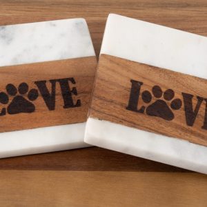 The Pair of Pet Square Coasters - Love features two square coasters with white marble tops and bottoms, accented by a wooden band in the middle. The wooden section is engraved with the word "LOVE," where the “O” is creatively replaced by a paw print, symbolizing affection for pets. These charming pet-themed coasters are perfect for placing on any wooden surface.