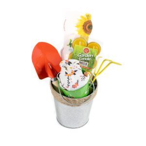 The "Love My Garden" small galvanized metal bucket features a charming "Love My Garden" design and includes a red hand shovel, yellow hand rake, floral-patterned gardening gloves, sunflower seeds, and garden candles. It boasts a natural fiber handle with the gardening tools extending from the top.