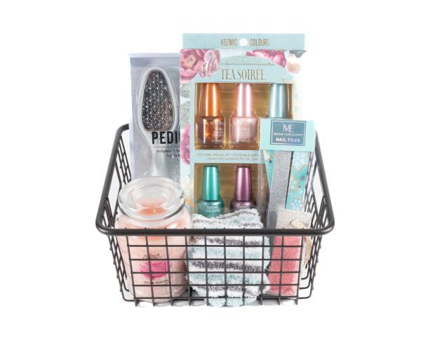 The Manicure/Pedicure Basket features a collection of various beauty and self-care essentials, including nail polishes for a perfect manicure, nail files, a soothing candle, a foot peel mask for an ideal pedicure, and a pair of soft socks. These brightly colored items are neatly arranged in the black wire basket.