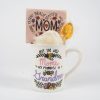 The Promoted to Grandma Mug Gift Basket with Food Certificate includes a white Grandma Mug decorated with vibrant floral patterns and the phrase "Only the best Moms get promoted to Grandma." Inside, there is a wooden sign that reads "MOM," surrounded by affirmations such as "patient," "brave," and "beautiful." Also included are a bath sponge, a packet, and a Food Certificate—an ideal addition to any heartfelt gift basket.