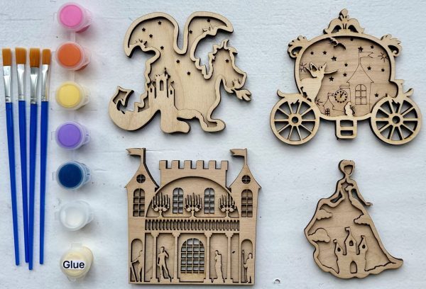 The image displays the Princess Craft Kit, which includes four unpainted wooden figures: a dragon, a horse-drawn carriage, a castle, and a princess. The kit also comes with five small paint pots in yellow, pink, purple, orange, and blue. Additionally, it contains a glue container and four paintbrushes.