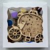 The Princess Craft Kit features a decorative wooden ornament shaped like a carriage housed in a box, showcasing designs of a ghost, a clock, and a house adorned with star cutouts. The kit also includes small paint pots in an array of colors.