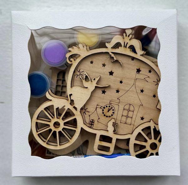 The Princess Craft Kit features a decorative wooden ornament shaped like a carriage housed in a box, showcasing designs of a ghost, a clock, and a house adorned with star cutouts. The kit also includes small paint pots in an array of colors.