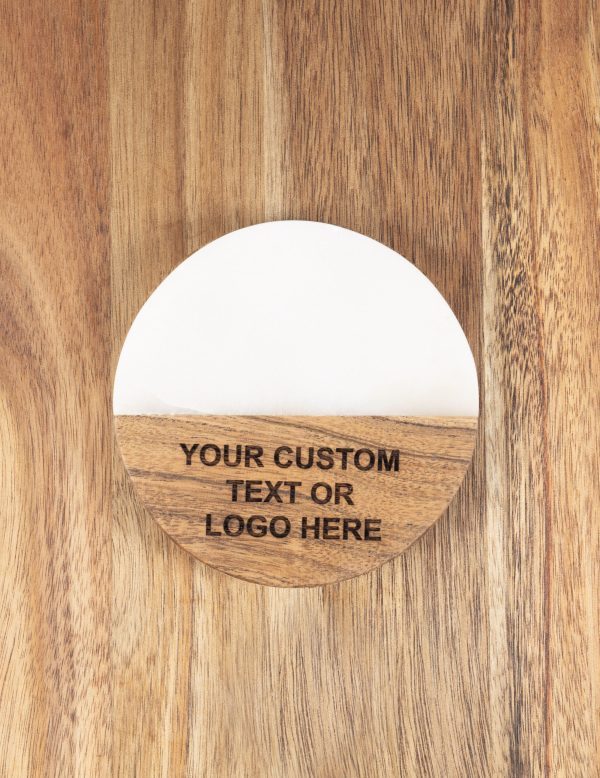 The "Pair Round Coasters - Your Custom Text/Logo Here" features a round, wooden, flat design with a smooth finish and a white top section. The bottom wooden portion is engraved with the text "YOUR CUSTOM TEXT OR LOGO HERE." These personalized coasters are placed on a wooden surface.