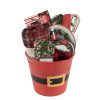 Red Santa bucket filled with Christmas home decor and fleece blanket