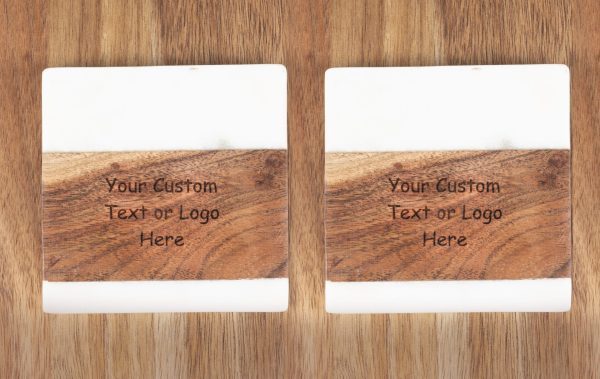 A pair of the "Pair Square Coasters - Your Custom Text/Logo Here" with white tops are placed on a wooden surface. Each coaster features an engraved section that reads, "Your Custom Text or Logo Here." The design beautifully combines wood grain and smooth white material.