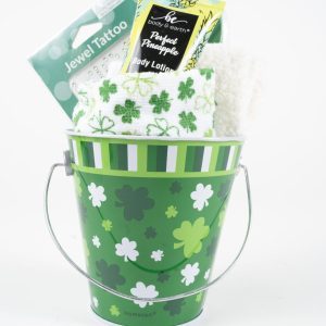 The St. Patrick's Day Pail with Free Food Certificate includes a green pail adorned with various green and white shamrocks, holding a fluffy white towel, a pineapple-scented body lotion, a green and white towel with shamrocks, and a package of jewel tattoos—perfect for celebrating St. Patrick's Day in style.