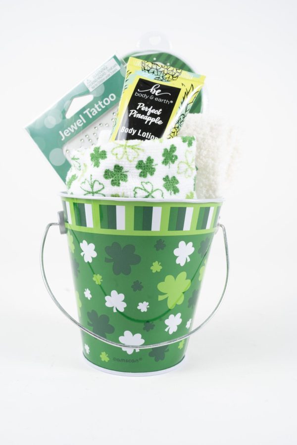 The St. Patrick's Day Pail with Free Food Certificate includes a green pail adorned with various green and white shamrocks, holding a fluffy white towel, a pineapple-scented body lotion, a green and white towel with shamrocks, and a package of jewel tattoos—perfect for celebrating St. Patrick's Day in style.