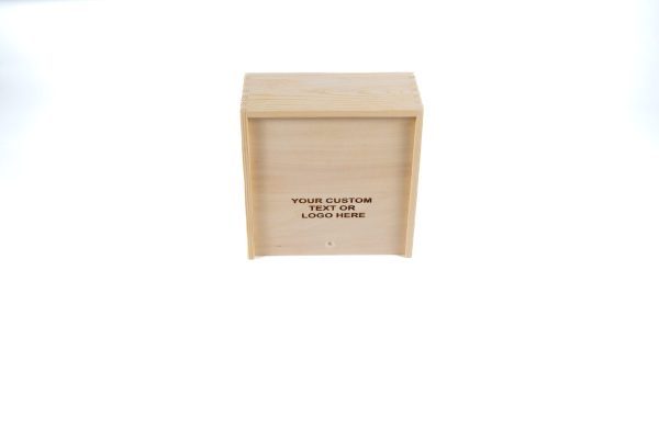 A Wooden Gift Box - Medium Crate with a flat lid, placed on a white background. The front of the medium crate includes a space for personalization, showcasing the words "YOUR CUSTOM TEXT OR LOGO HERE" printed in the center. The wood has a light, natural finish.