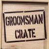 The "Groomsman Crate - Wooden Gift Box" features the words "GROOMSMAN CRATE" boldly stenciled in uppercase letters on the front, framed by a rectangular border, and boasts a light, natural wood grain finish.