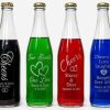 Personalized 12oz glass wedding favor bottles with custom logo engraving and gold lids.