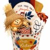 Fall kitchen decor gift basket featuring dishtowels and autumn home accents in a festive tin